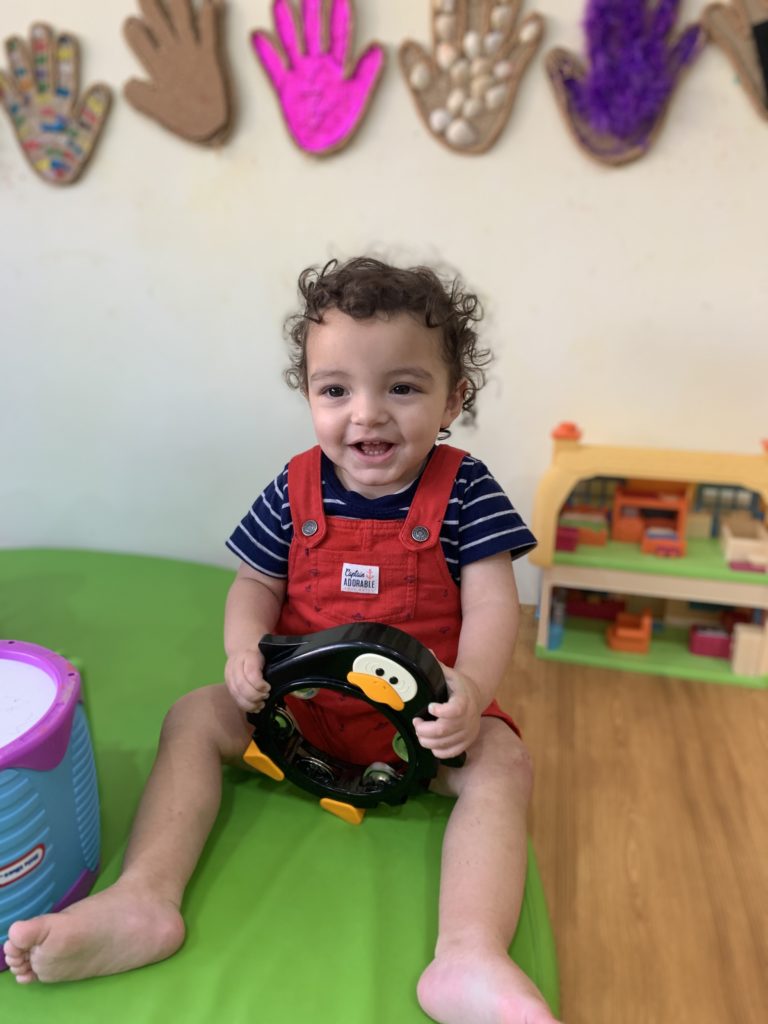 Toddler playing with musical instrument during nursery class