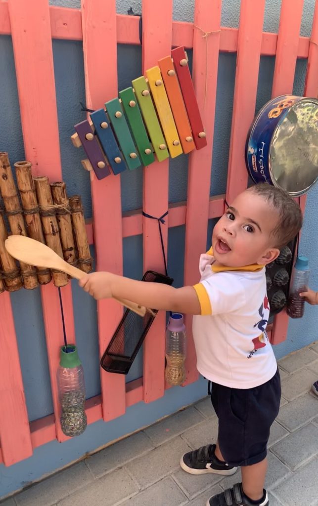 Toddler boy playing with different kinds of xylophones