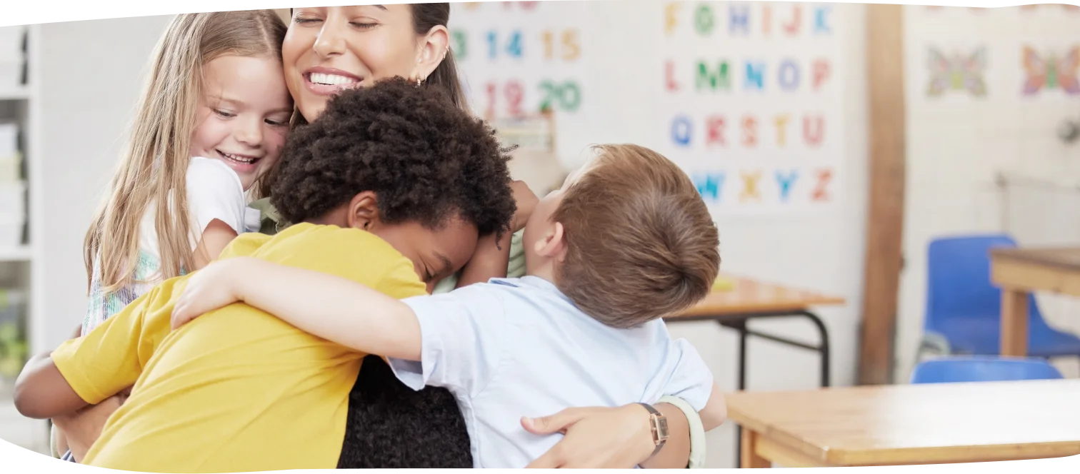 Children hugging their teacher at Step by Step Nursery