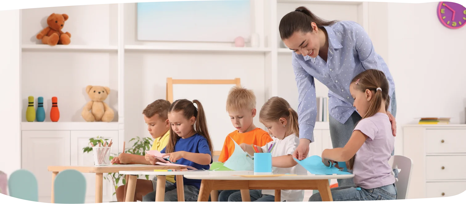 Step by Step Nursery teacher leading a craft activity