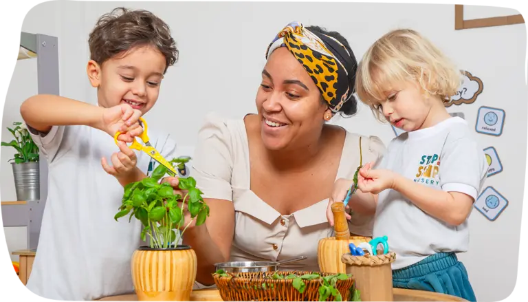 Nursery-aged children exploring small world play with a teacher at Step By Step Nursery Dubai, fostering imagination and creativity.